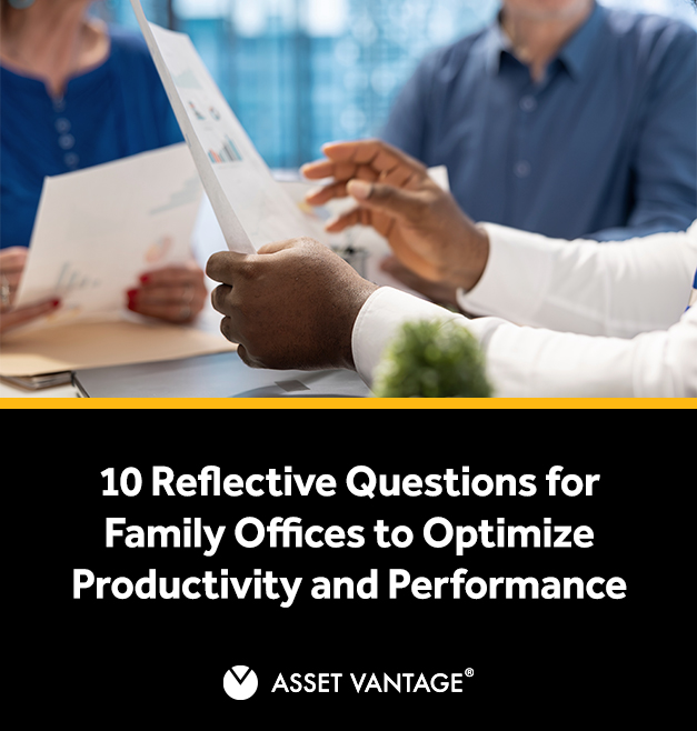 Close-up of hands holding documents in a business meeting. Multiple people discuss charts and reports, reflecting on strategic questions to optimize productivity and performance in family offices.