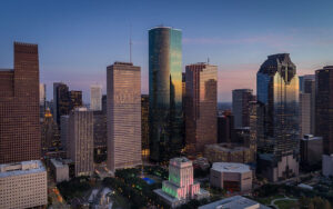 Houston cityscape at dusk with skyscrapers reflecting colorful lights, symbolizing how AV enables MFOs to drive business growth and cost efficiencies through streamlined processe