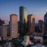 Houston cityscape at dusk with skyscrapers reflecting colorful lights, symbolizing how AV enables MFOs to drive business growth and cost efficiencies through streamlined processe
